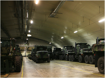 Military vehicles sitting in a tent.