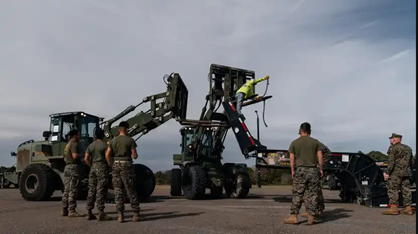 A handful of Marines standing around some equipment on a ship.